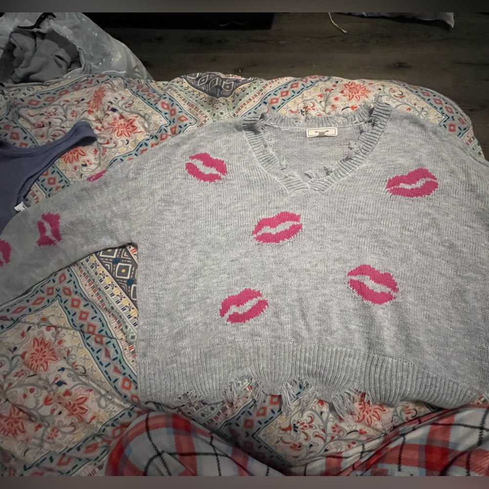 grey sweater with pink kiss logos